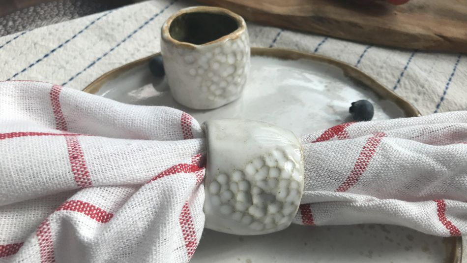 Ceramiczna obrączka do serwetki z białym szkliwem i fakturą bąbelkową w aranżacji stołu