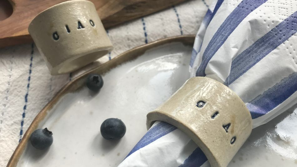 Ceramiczna obrączka do serwetki z napisem „CIAO” na talerzu w stylizacji śniadaniowej