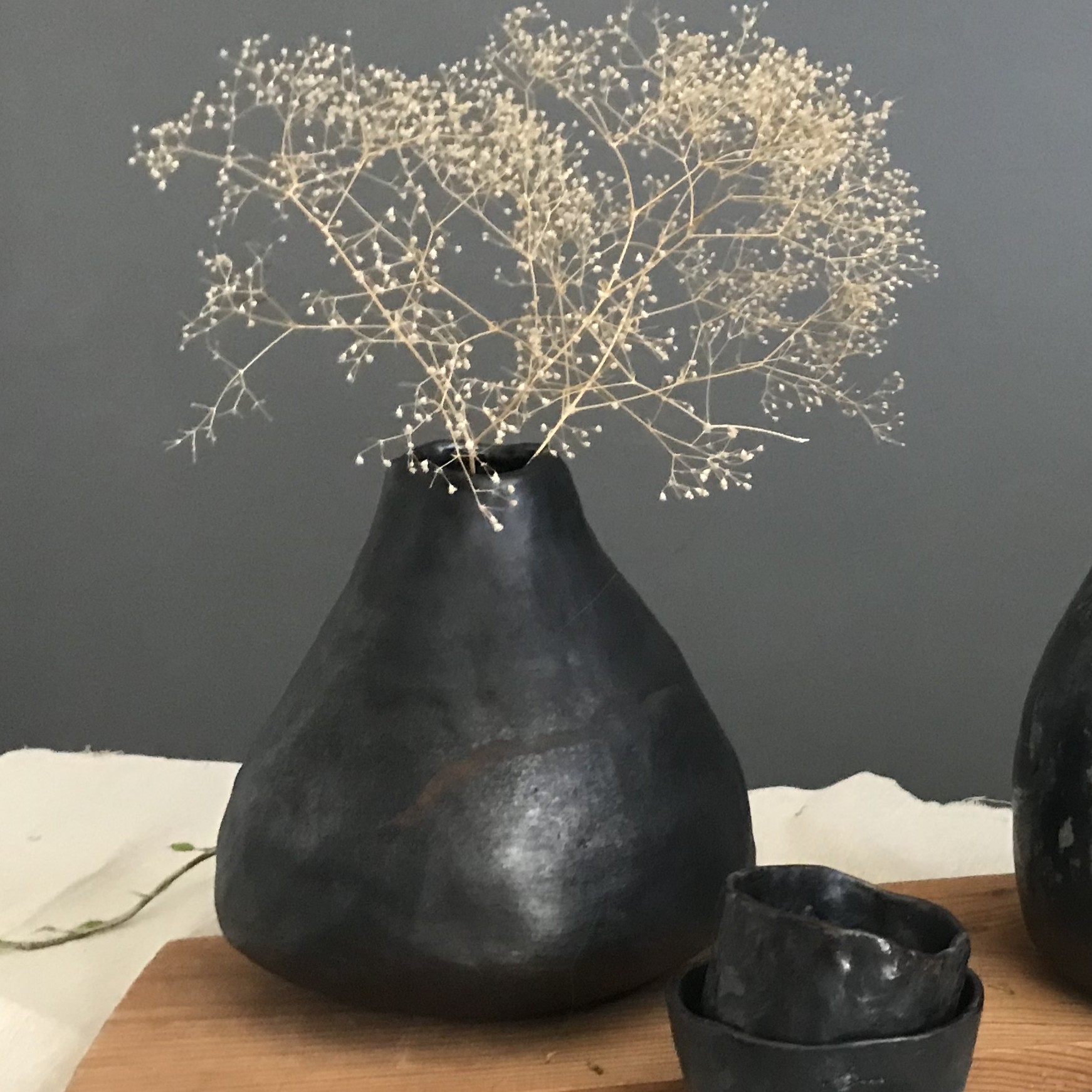 Smukły czarny wazon ceramiczny z czarnej gliny, wypalany w redukcji.