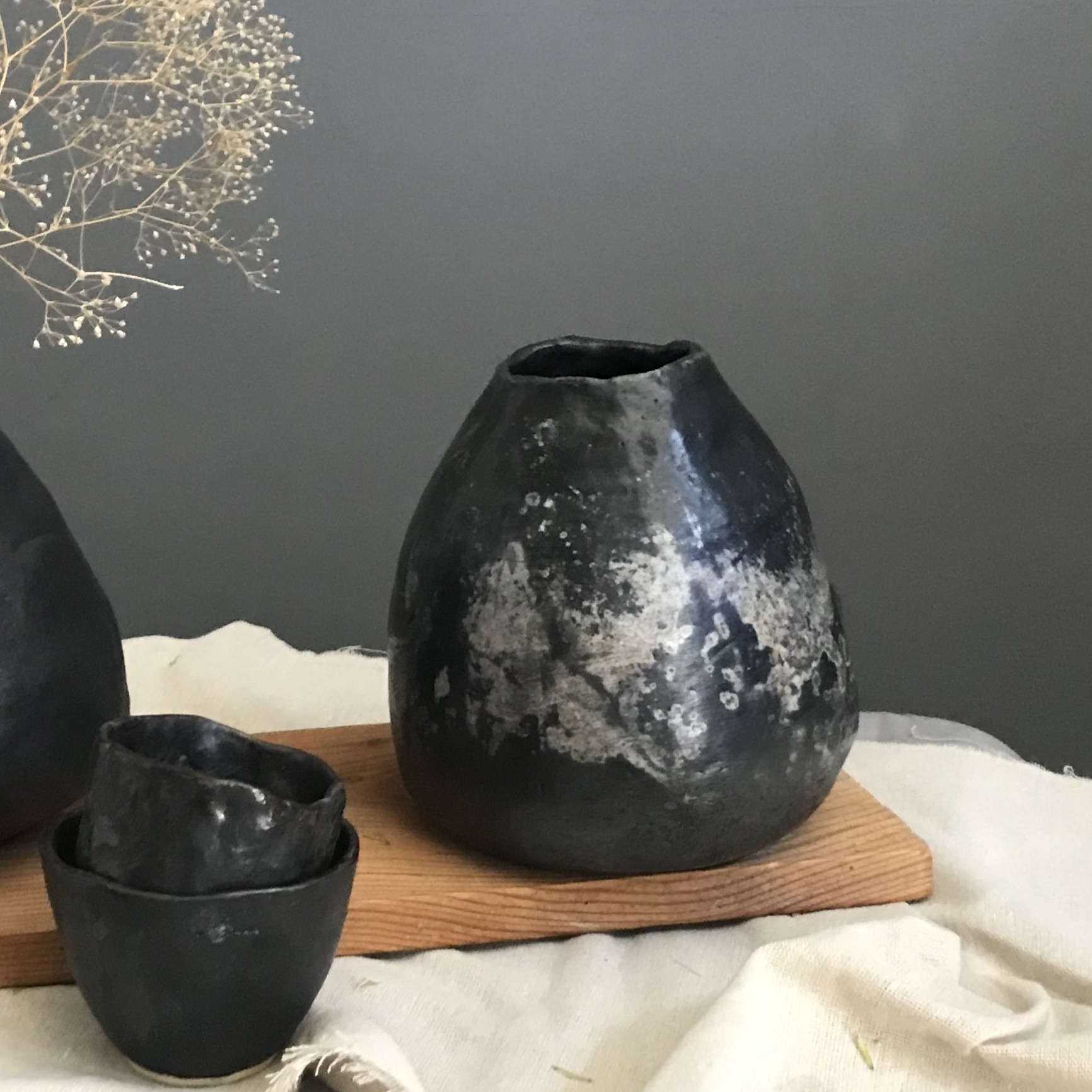 Czarny, ręcznie formowany wazon ceramiczny o pękatej formie z efektami redukcji.