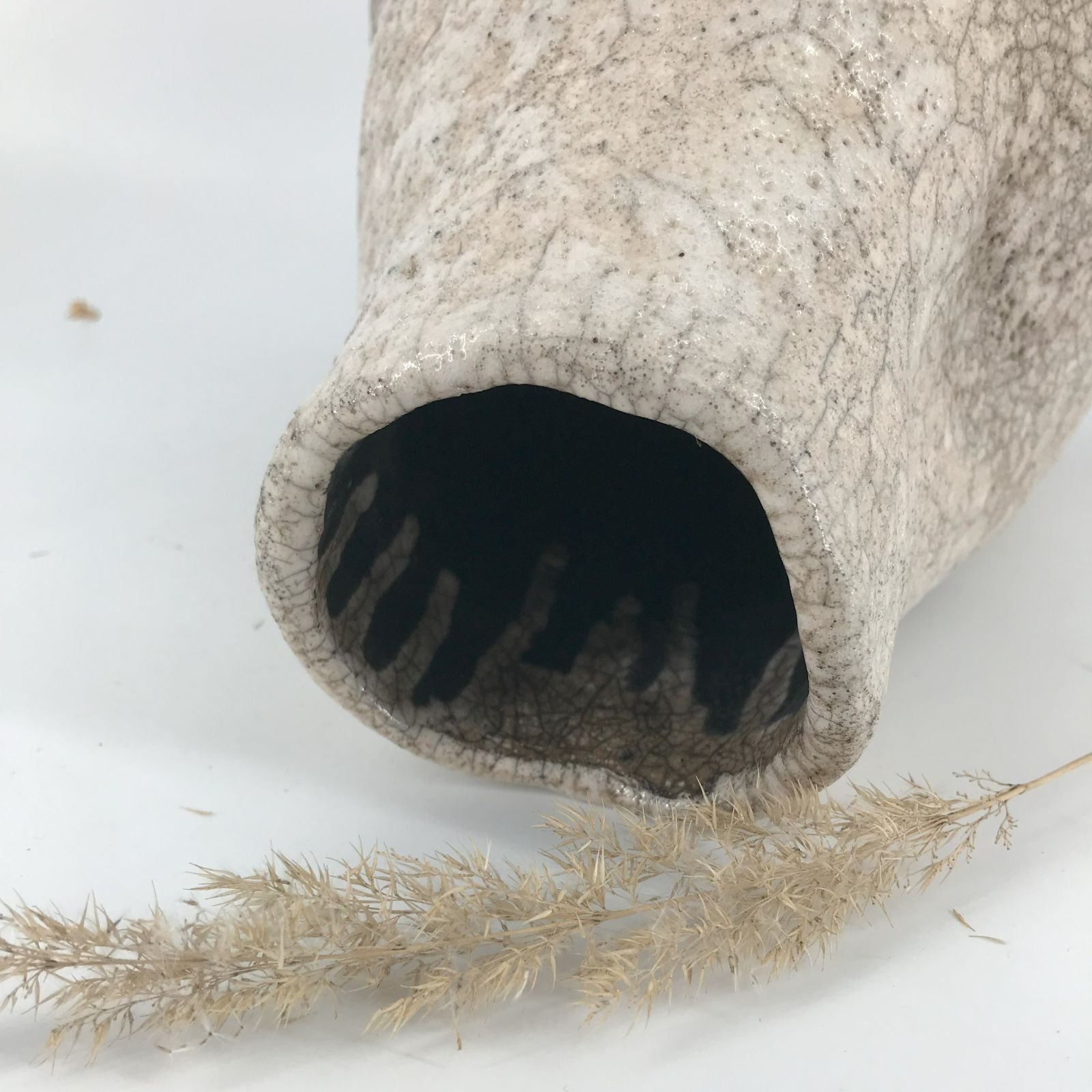 Zbliżenie otworu wazy z widocznym ciemnym wnętrzem i dekorem