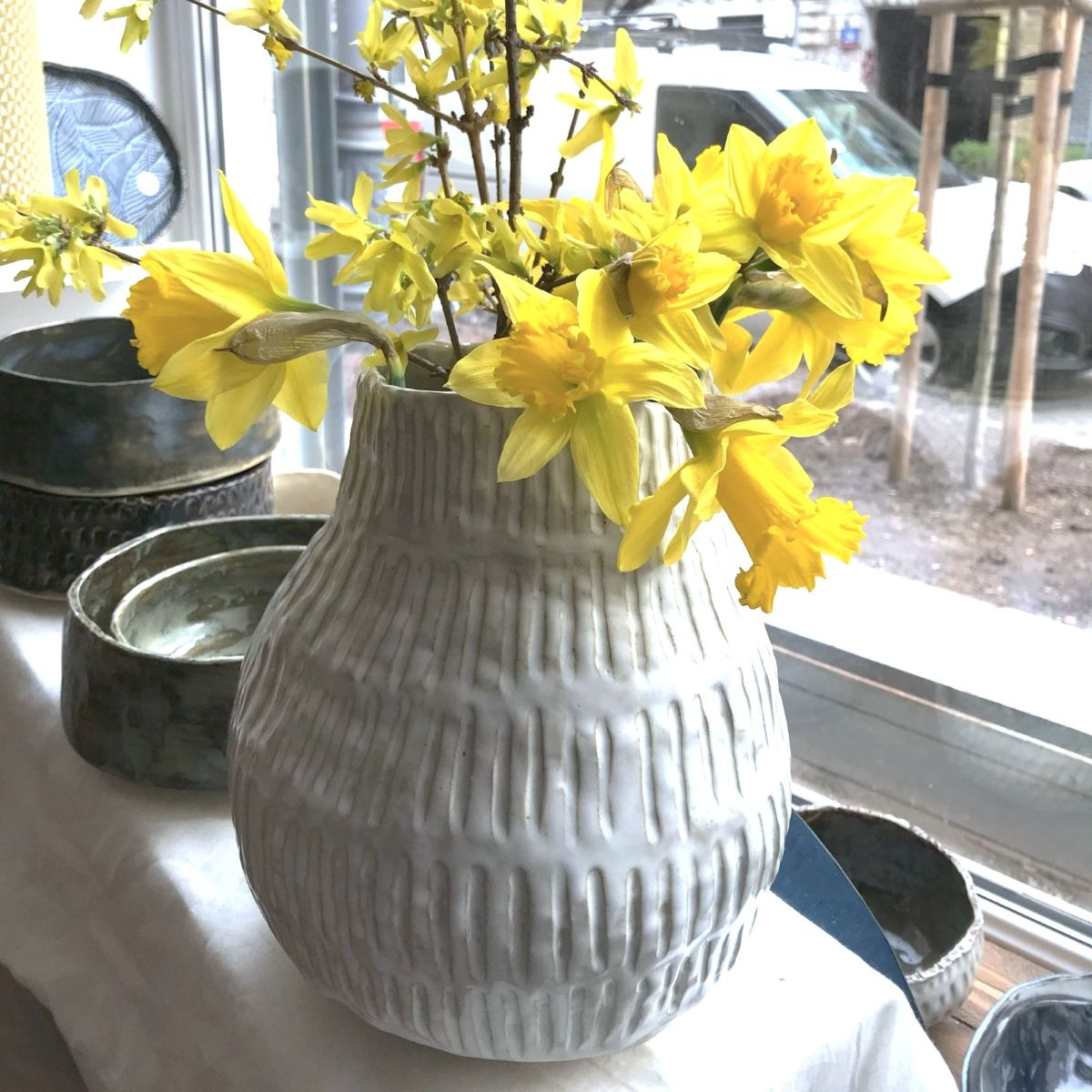 Ręcznie wykonany wazon z kamionki SHIRO o miękkiej formie, z żółtymi narcyzami