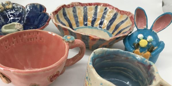 kolorowa ceramika wykonana przez dzieci – miski, kubki i figurka króliczka